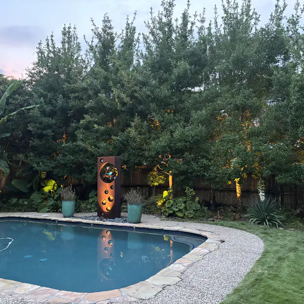 Pool and planting beds lit with low-voltage landscape lighting at blue hour