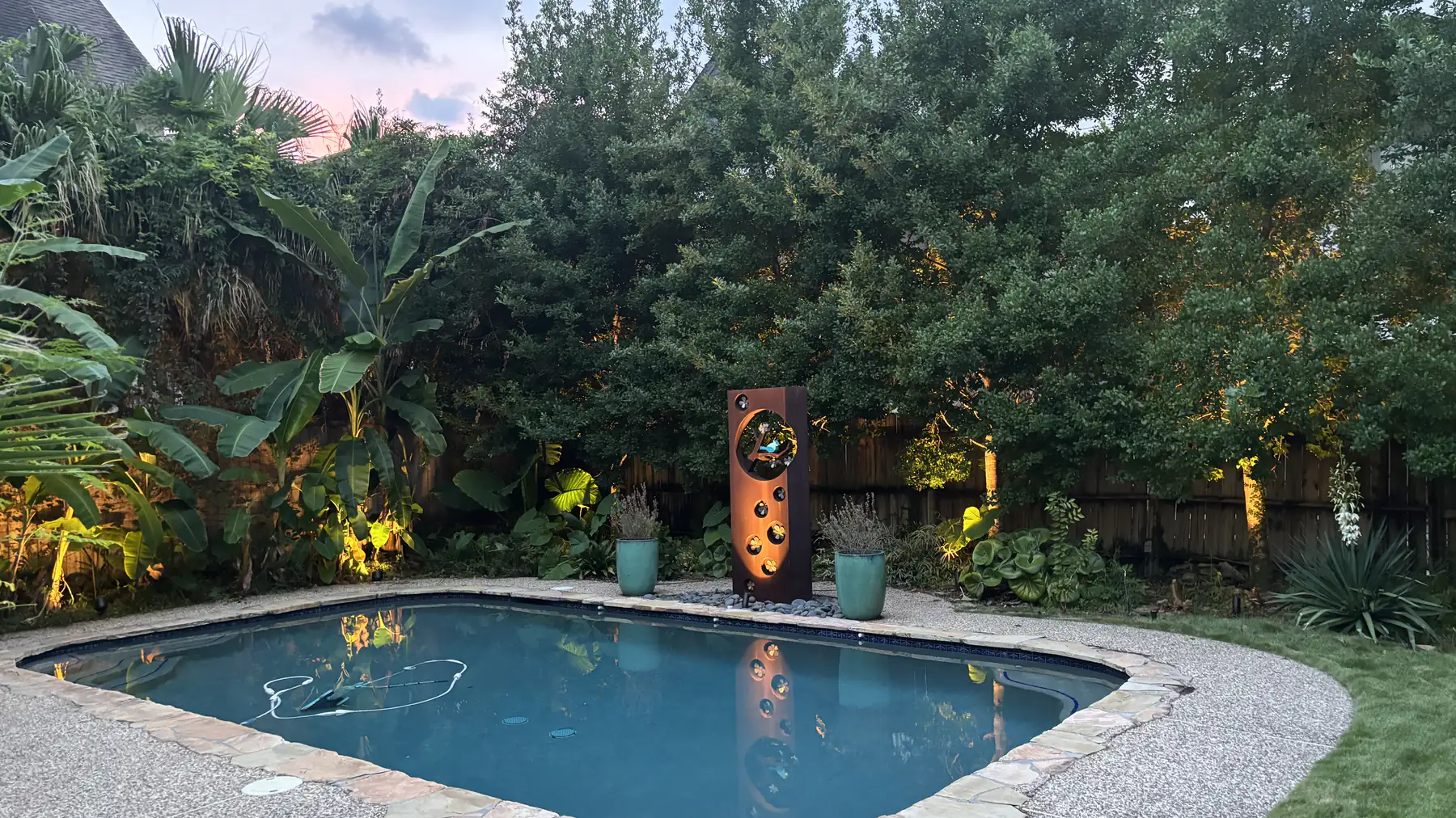 Pool and garden at blue hour with low-voltage uplighting through the planting