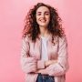 Beautiful girl in silk jacket smiling on pink background